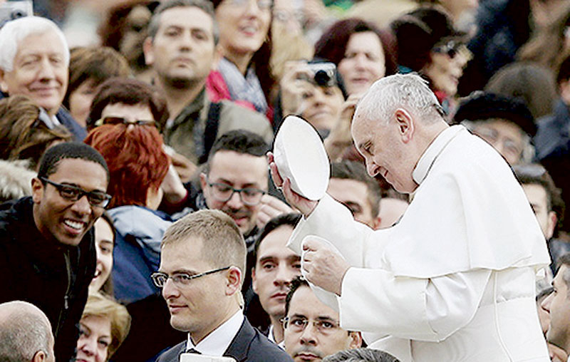 Pope tries on zucchetto as he arrives for general audience in St. Peter's Square at Vatican
